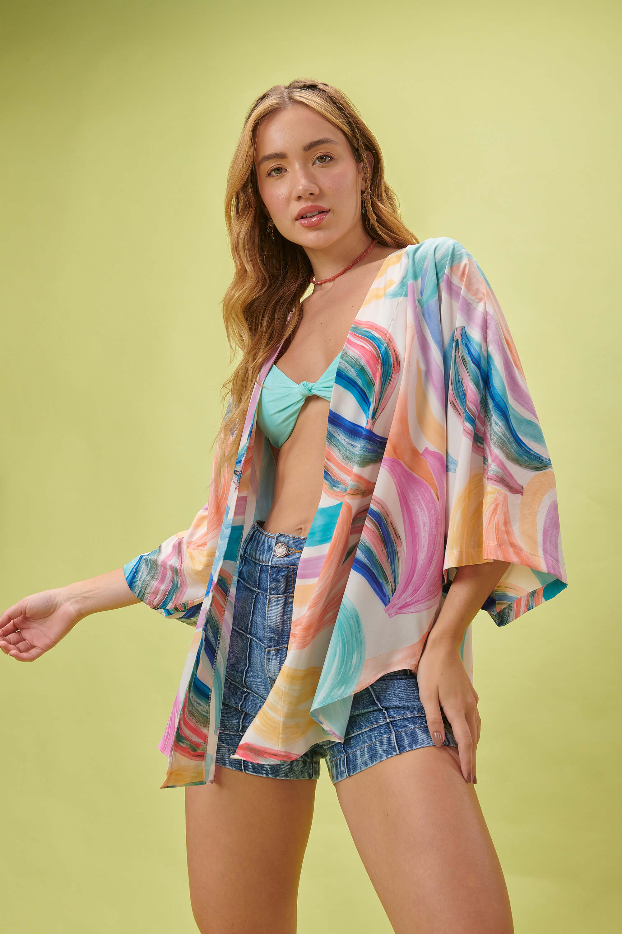 A stylish Oceana Blue bikini swimwear set paired with Isabella denim jean shorts and a Banana Beach kimono, part of DESIRE DENIM’s women’s tropical summer apparel collection.